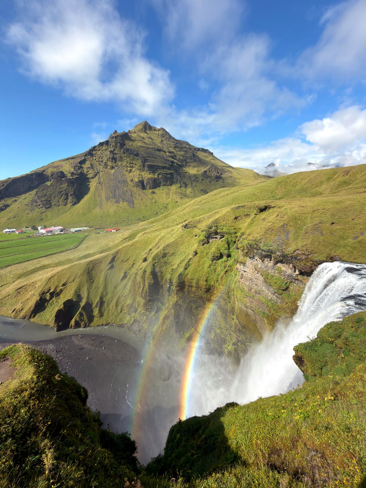 Skógafoss from the clifftop with a rainbow in the spray
