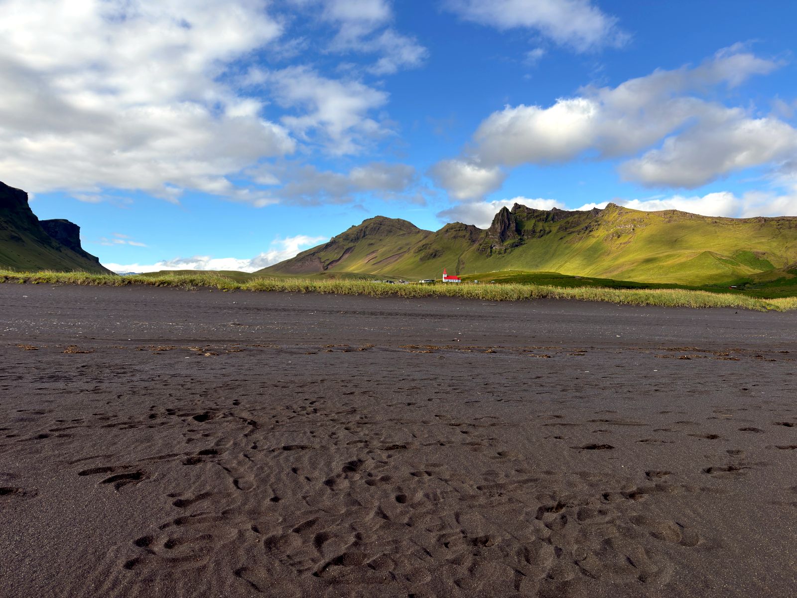 Black sand beach with the red-roofed church of Vík behind
